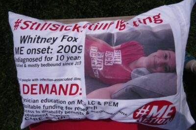 a pillow on a white pillowcase and a picture of a woman lying on a couch