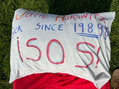 A pillow that reads "Julie Horowitz, Sick since 1989! ¡SOS!"