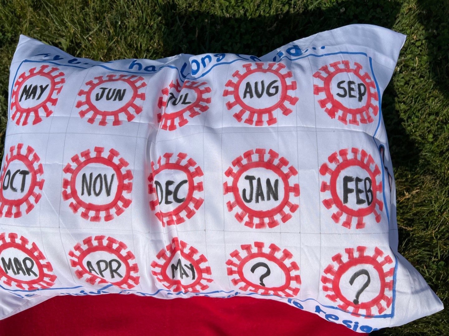 A white pillowcase with red covid 19 virus illustrations made into a calender